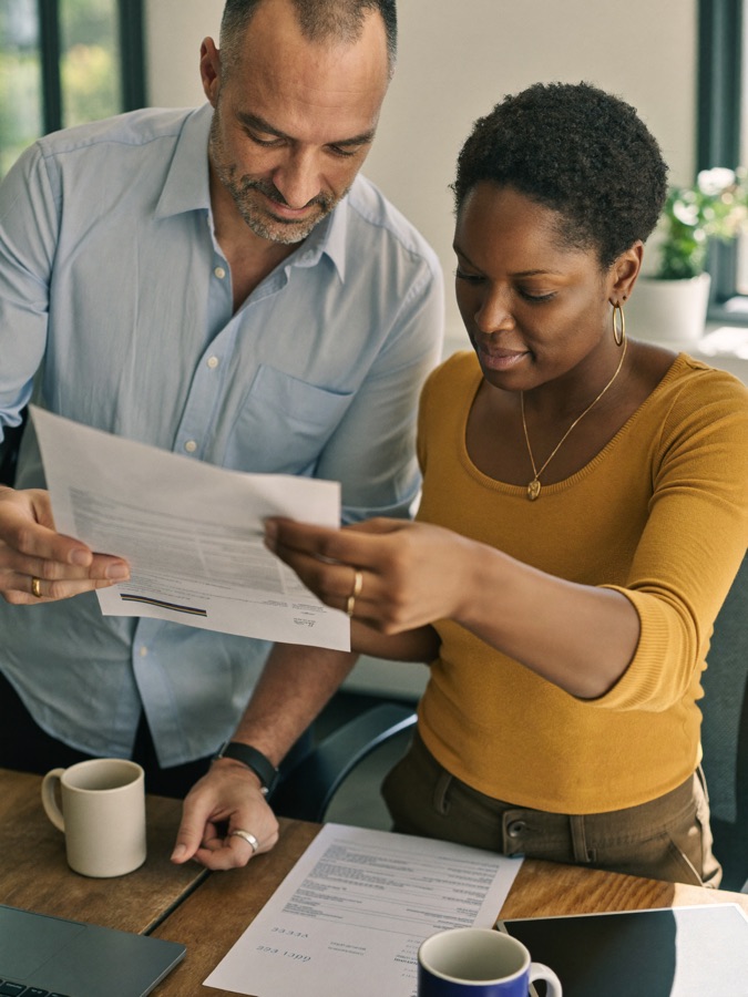 Two colleagues reviewing printed financial statements together